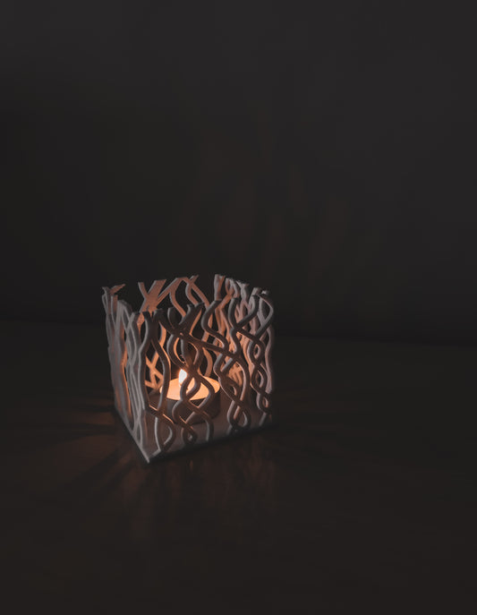 Organic cube candle holder casting glowing shadows modern home decor